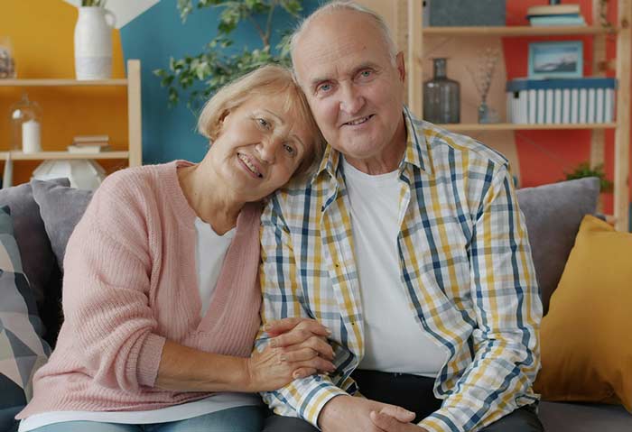 Happy elderly couple seated and smiling