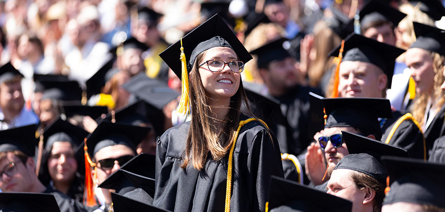 Student at Graduation looking at her fellow students with gladness.
